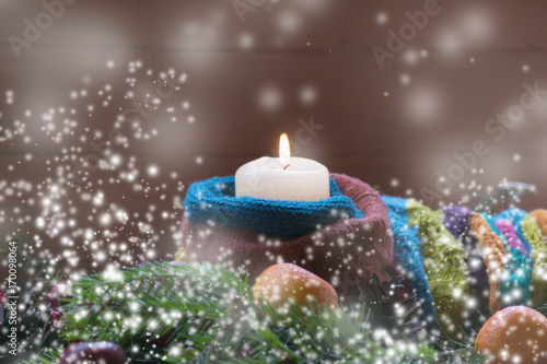 A man holds a candle. Christmas concept. Cones  tree  toys  holiday. Snow.