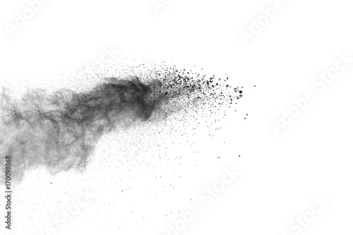 Black powder explosion. Closeup of black dust particles explode isolated on white background.