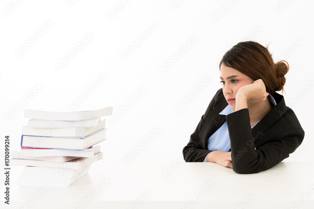 Young attractive confident bored Asian female business woman in suit blue shirt sitting on desk looking at stack of books for research on white background. Young attractive confident bored Asian female business woman in suit blue shirt sitting on desk looking at stack of books for research on white background.