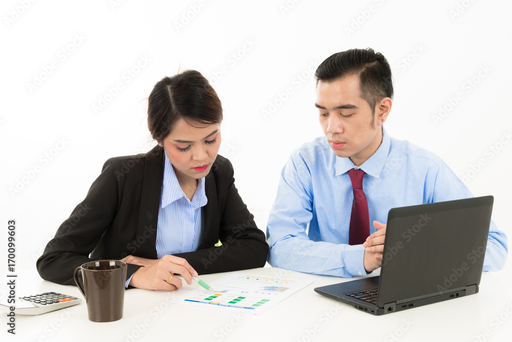 Young attractive confident Asian male business man and woman sitting on desk discussing work over coffee with laptop document on white background Young attractive confident Asian male business man and woman sitting on desk discussing work over coffee with laptop document on white background