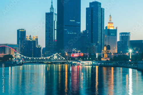 illuminated city waterfront downtown skyline with Haihe river Tianjin China.