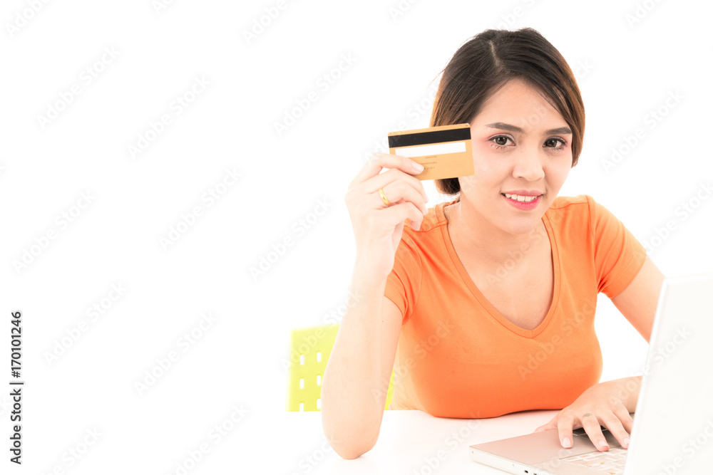 Beautiful young teen Asian orange shirt woman holding credit card with laptop on white background. Beautiful young teen Asian orange shirt woman holding credit card with laptop on white background.