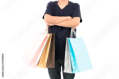 Young confident attractive Asian blue shirt man with shopping bags standing with portrait on white background.