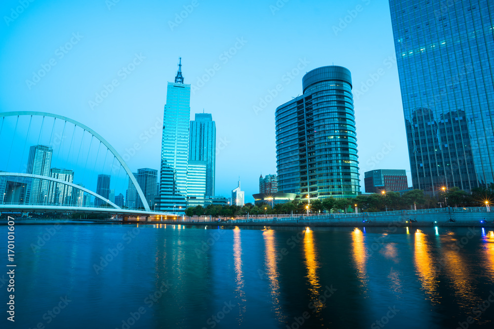 Obraz premium illuminated city waterfront downtown skyline with Haihe river,Tianjin,China.