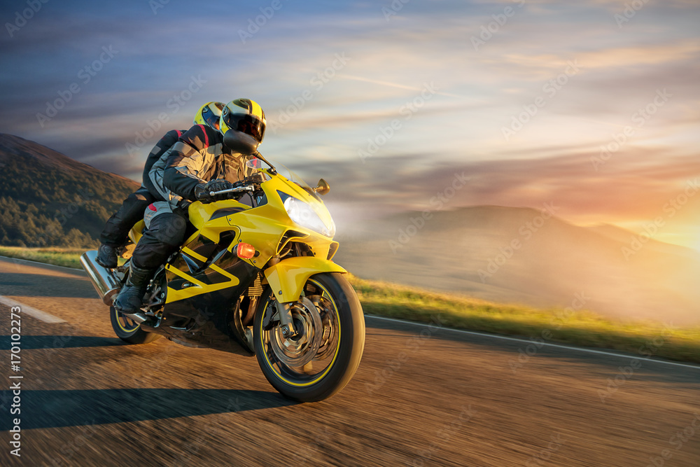 Fototapeta premium Motocykliści na sportowym motocyklu jeżdżącym w alpejskim krajobrazie.