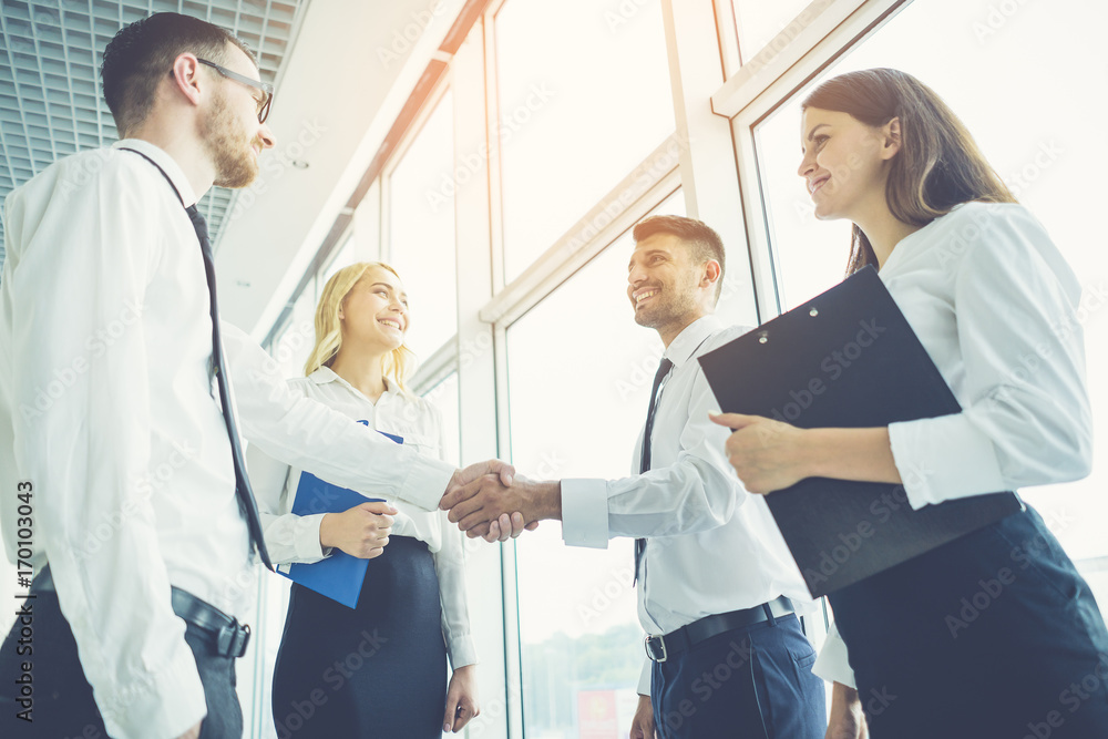 Obraz premium The business people handshake on the sunny background