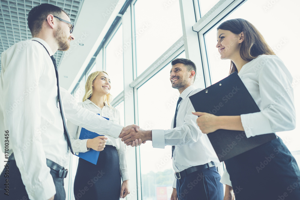 Fototapeta premium The business people handshake near the panoramic window