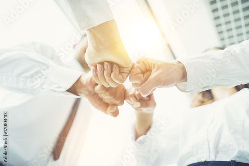 The business people greeting with a fist on the sunny background