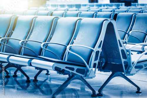 row of empty seats in airport lobby,blue toned,china.