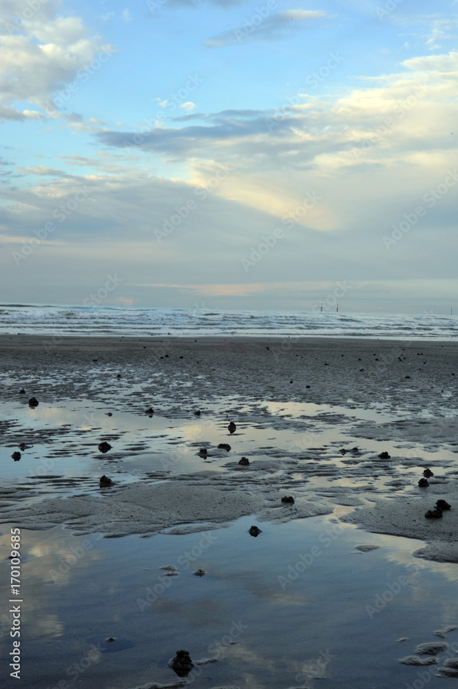 Wattwurmhaufen am Strand von Bibione mit Blick auf das Meer