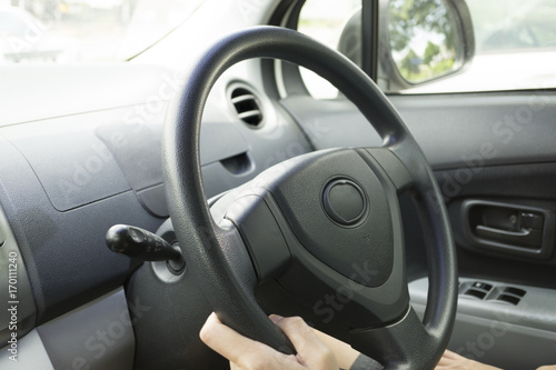 man's hand on steering wheel, driving or parking on the road background