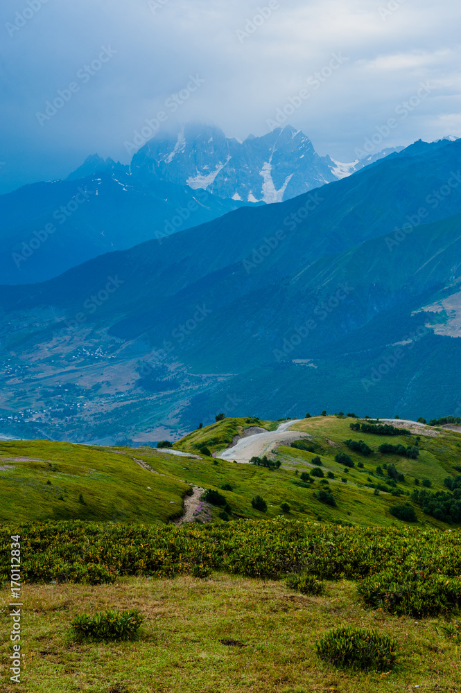 Mountain valley with snow peaks and clouds in Tetnuldi, Mestia, Georgia