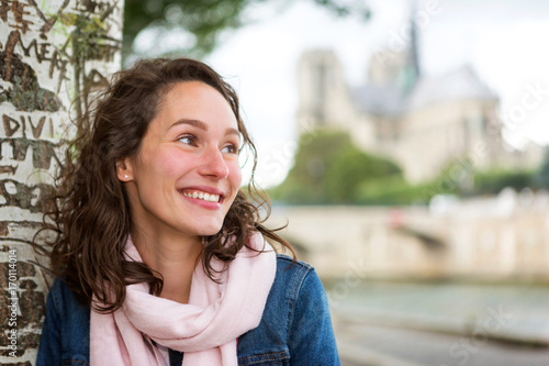 Portrait of a young tourist woman on Paris dock next to Notre Dame - Tourism and travel concept