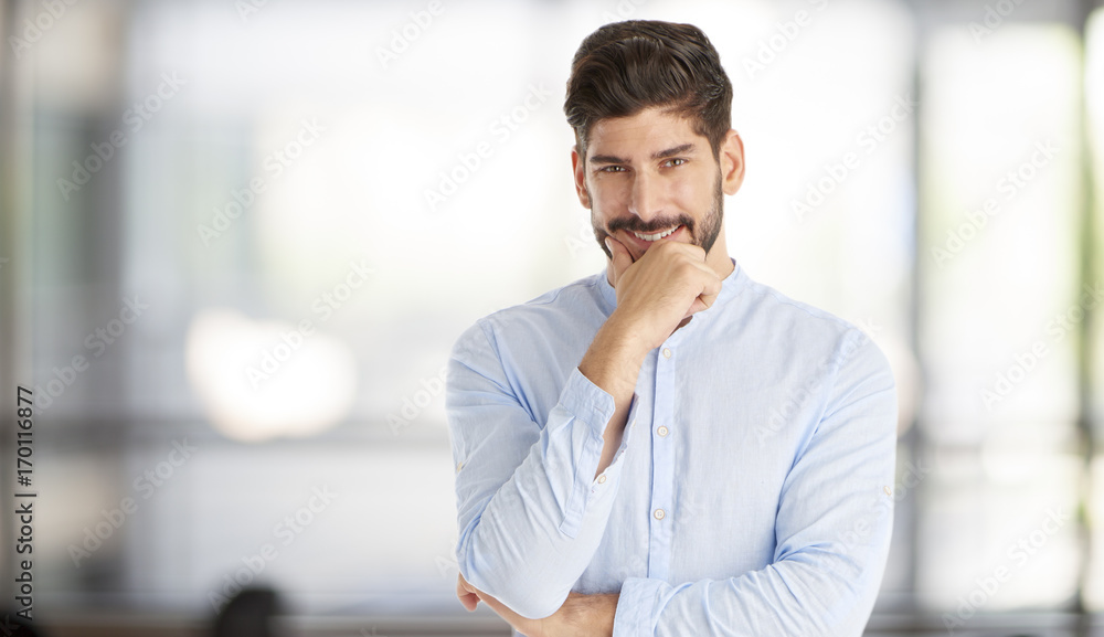 Thinking young businessman portrait. Shot of a young man standing with hand on chin and looking thoughtfully. Thinking young businessman portrait. Shot of a young man standing with hand on chin and looking thoughtfully.