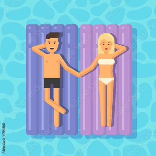 Man and woman floating on mattresses in a swimming pool holding hands
