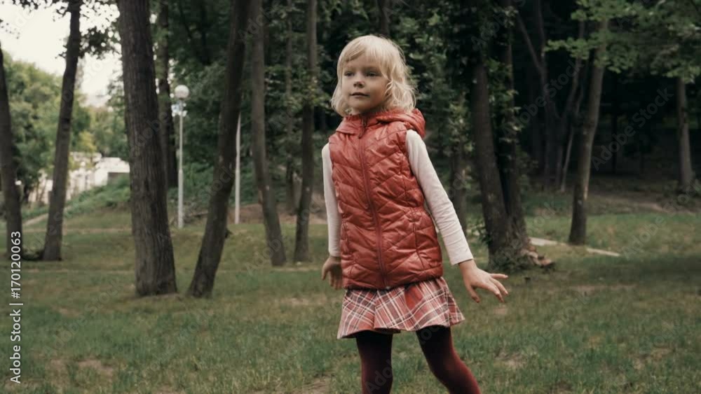 The little fun blond girl throwing a piece of a plastic shaped like a plate as a game. Slow motion. HD The little fun blond girl throwing a piece of a plastic shaped like a plate as a game. Slow motion. HD