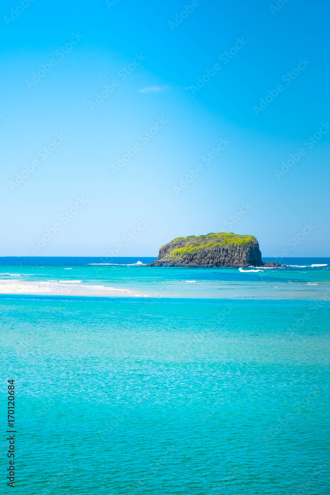 rock island surrounding by blue sky and crystal sea water  