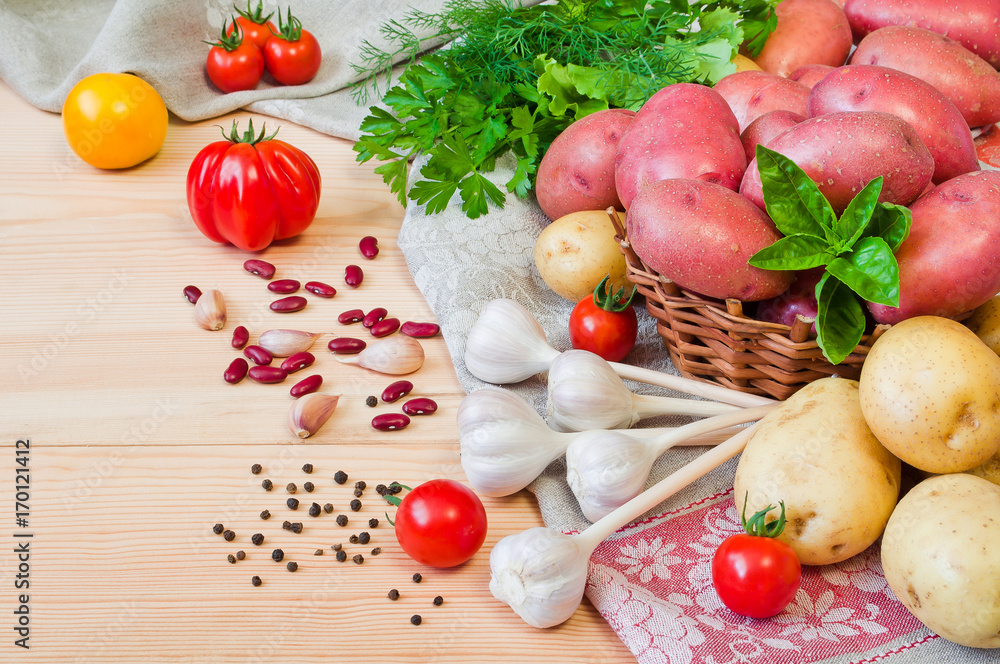 Potatoes and other vegetables on a wooden table Potatoes and other vegetables on a wooden table