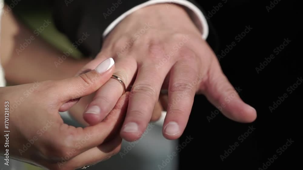 Bride and groom exchanging wedding rings on ceremony outdoors Bride and groom exchanging wedding rings on ceremony outdoors