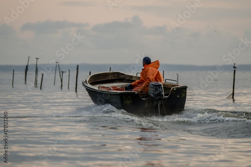 Ein Fischer fährt am frühen Morgen hinaus aufs Wasser. photo