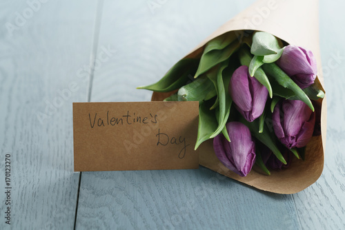 tulips on blue wood background with valentines day greeting card