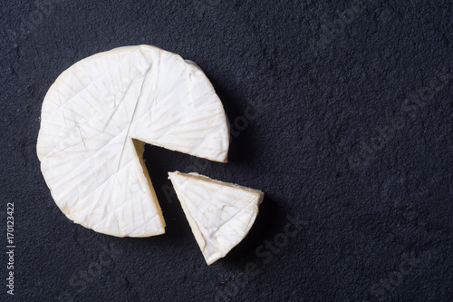 Cheese brie on dark stone background