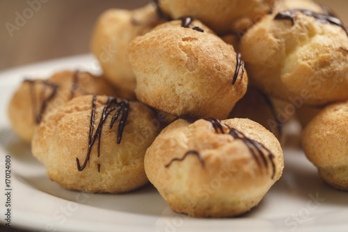 closeup profiteroles with fine dark chocolate on plate