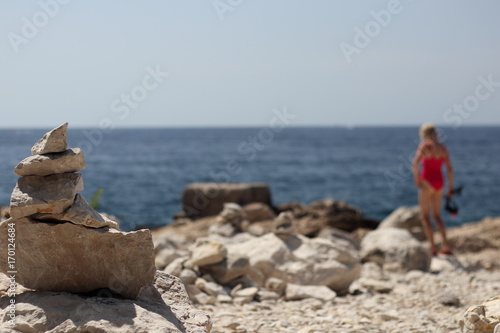 Steinsymbol mit badendem Mädchen im Hintergrund