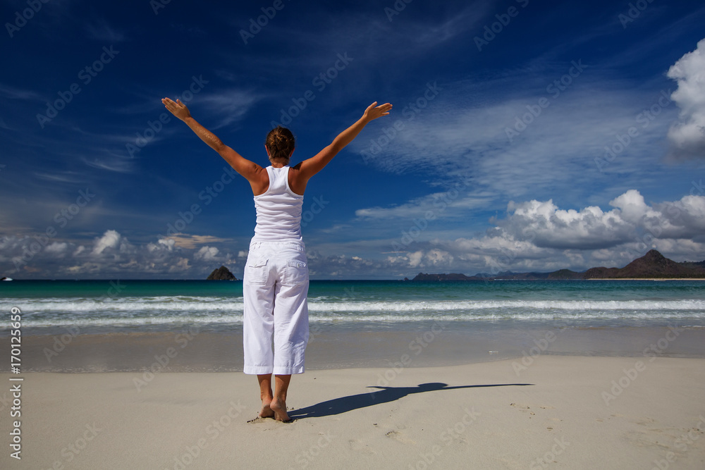 Caucasian woman practicing yoga at seashore of tropic ocean Caucasian woman practicing yoga at seashore of tropic ocean