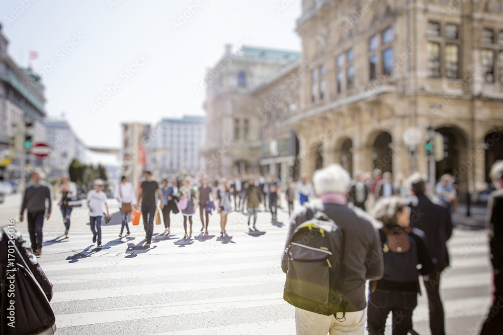 Crowd of anonymous people walking on busy city street