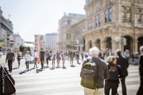 Crowd of anonymous people walking on busy city street