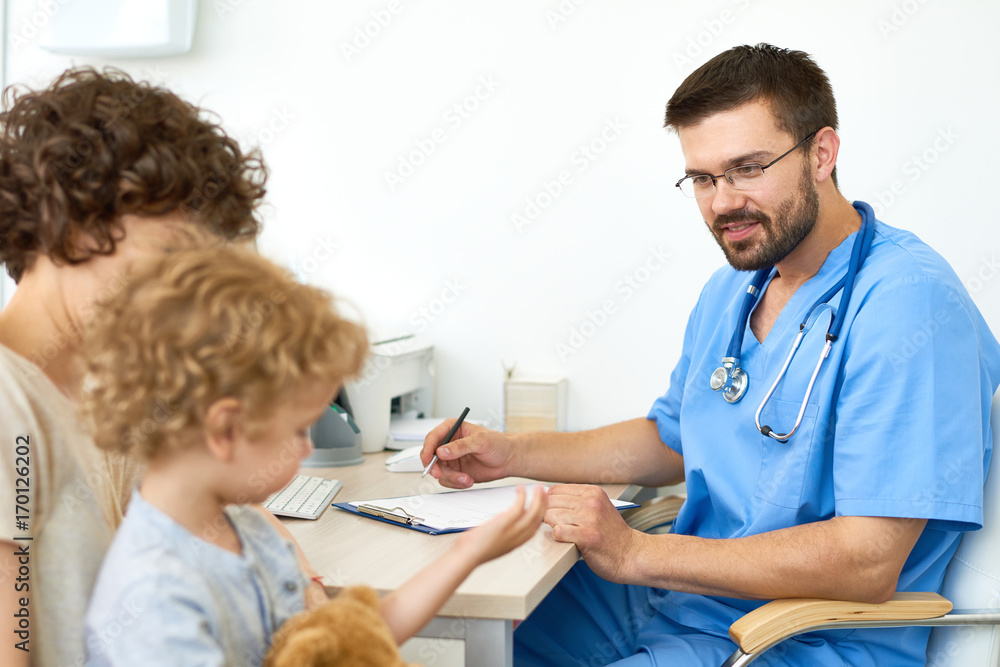 Portrait of smiling doctor talking to little boy in appointment Portrait of smiling doctor talking to little boy in appointment