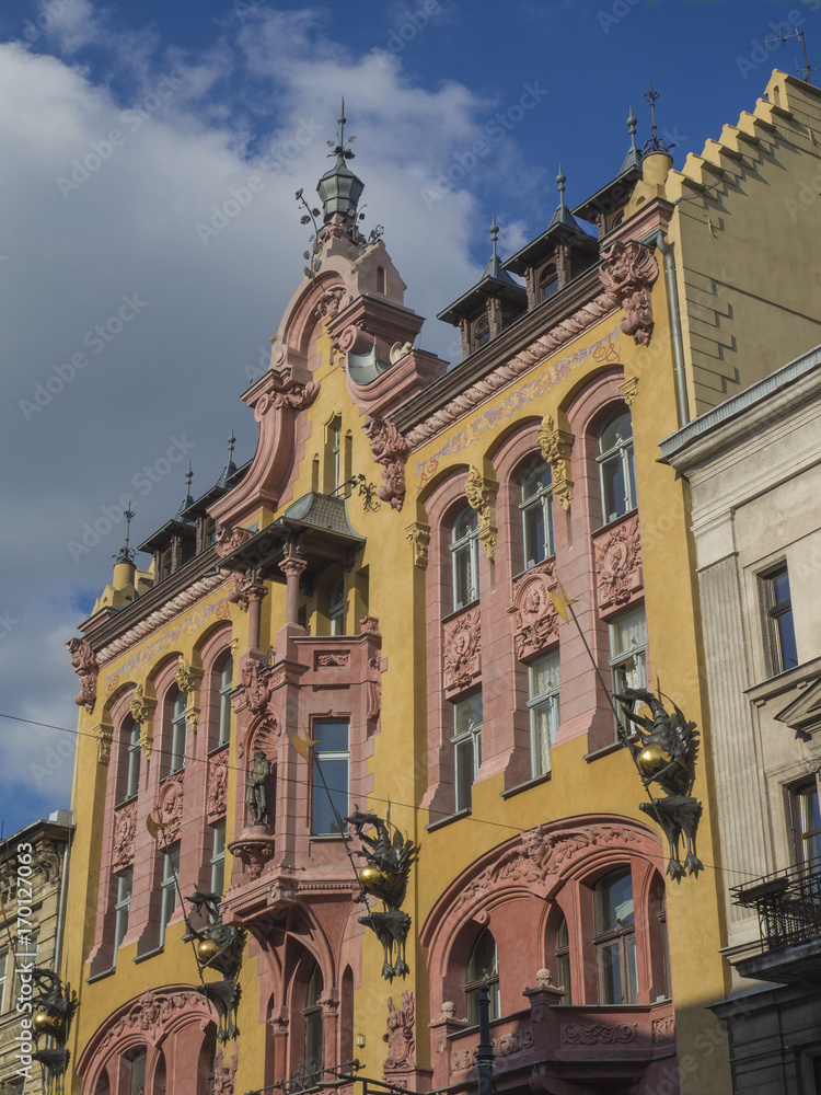 yellow and pink palace with dragon statue in Lodz city center with blue sky background Polandy background Poland