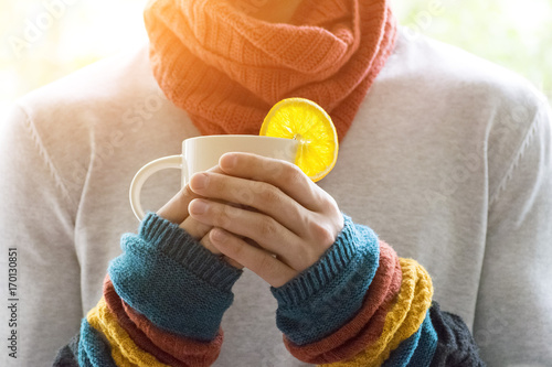 A young man holding a Cup of tea and lemon. Cold, cold, disease.
