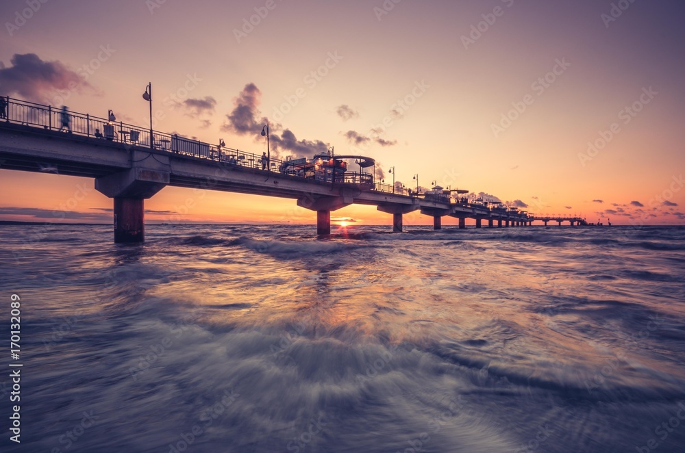 Fototapeta premium Molo w kurorcie Międzyzdroje - Bałtycki krajobraz o zachodzie słońca, Polska