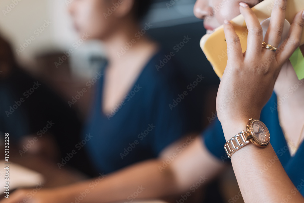 Close up Young Asian women using smartphone in meeting room at coffee shop in selective focus.