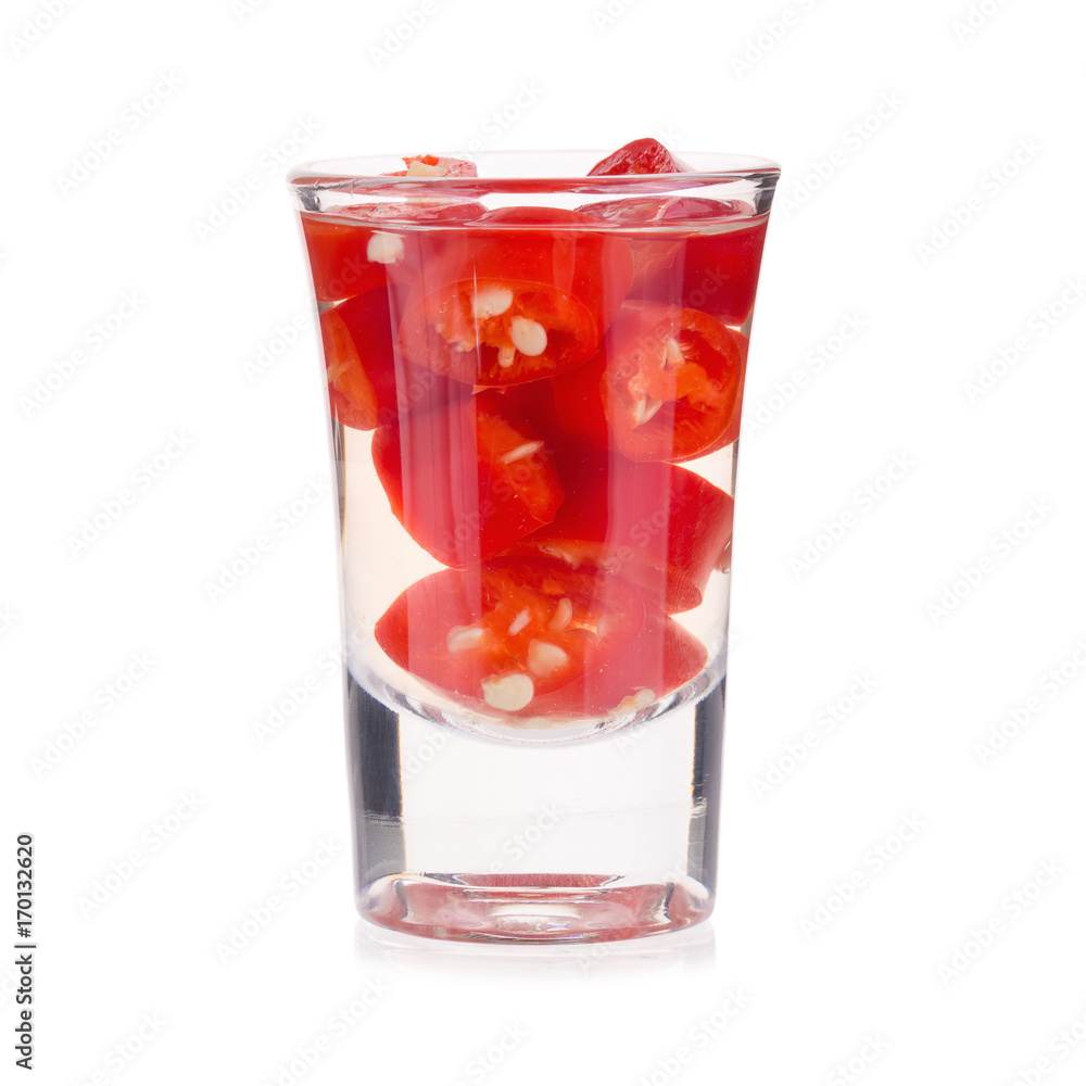 Slices of preserved red hot pepper in glass isolated on a white background Slices of preserved red hot pepper in glass isolated on a white background