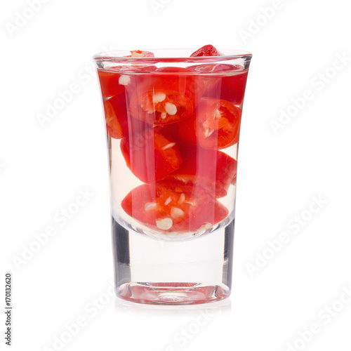 Slices of preserved red hot pepper in glass isolated on a white background