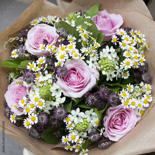 the Bouquet of roses  chamomile and eustoma in craft paper for wedding