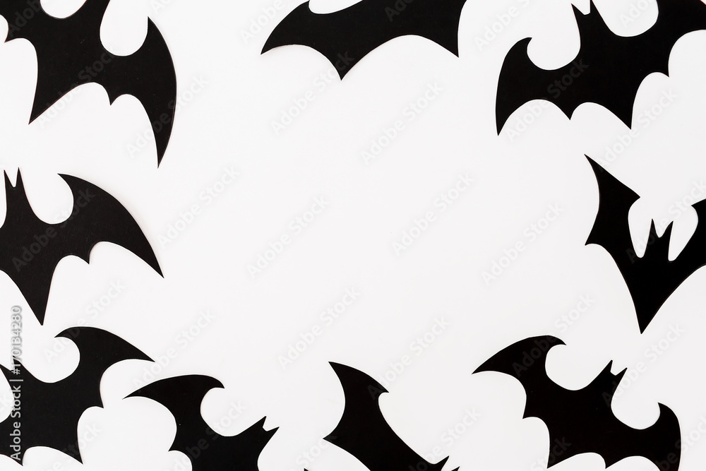 Halloween holiday frame. Handmade black paper bats on white background. Flat lay, top view. Halloween holiday frame. Handmade black paper bats on white background. Flat lay, top view.