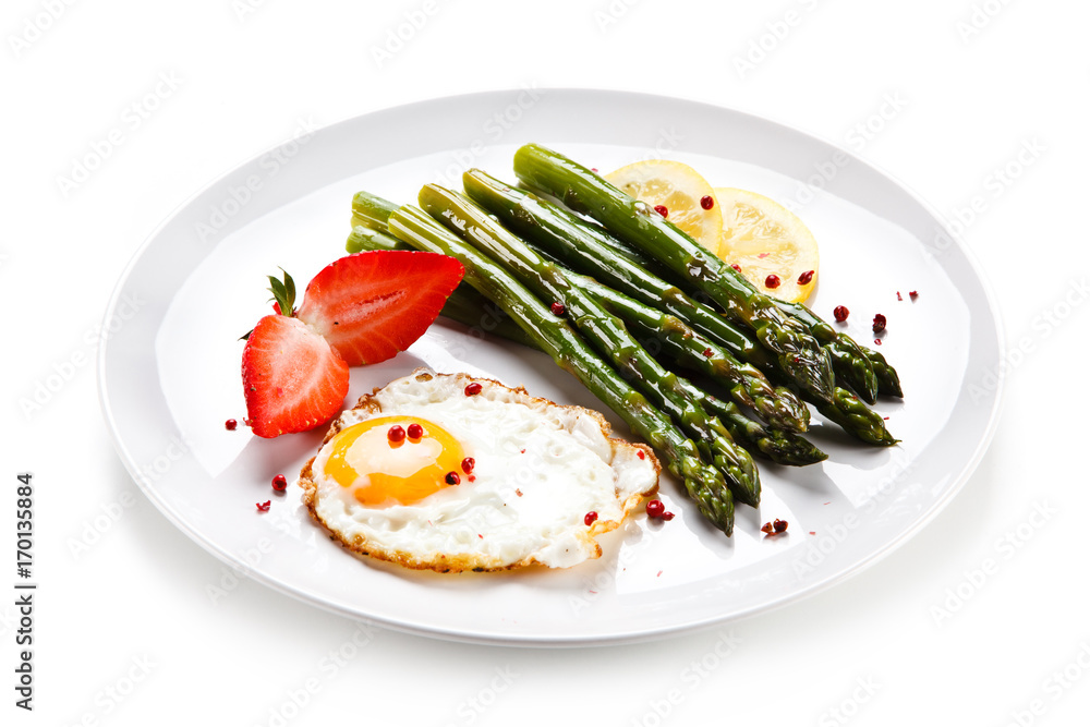 Fried egg with asparagus on white background Fried egg with asparagus on white background