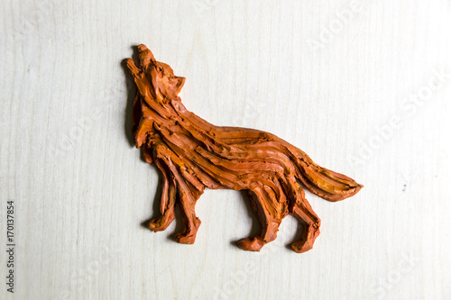 Handmade Figurine made of clay  plasticine on a wooden background