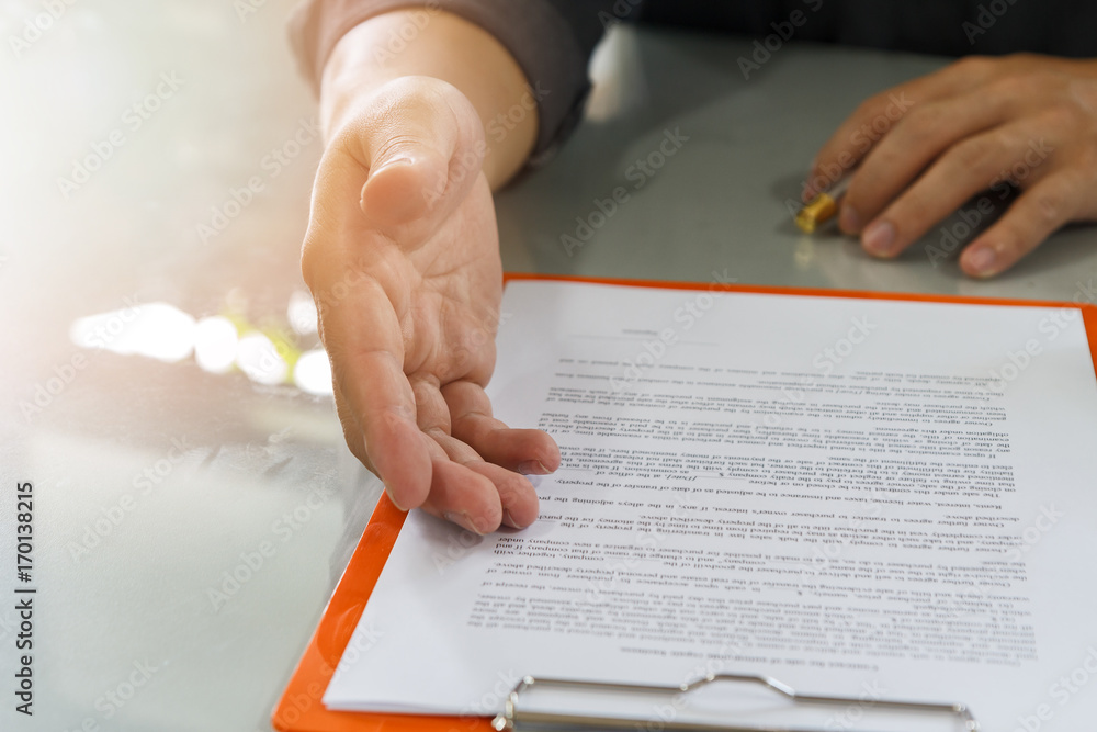 Businessman offering contract paper to his business partner for sign contract
