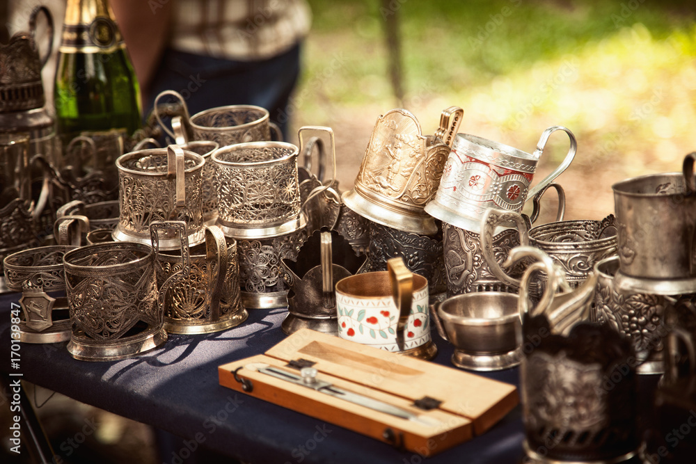 Lot of antique metal glass holders at a flea market. Many old ornate cup holders at a garage sale Lot of antique metal glass holders at a flea market. Many old ornate cup holders at a garage sale