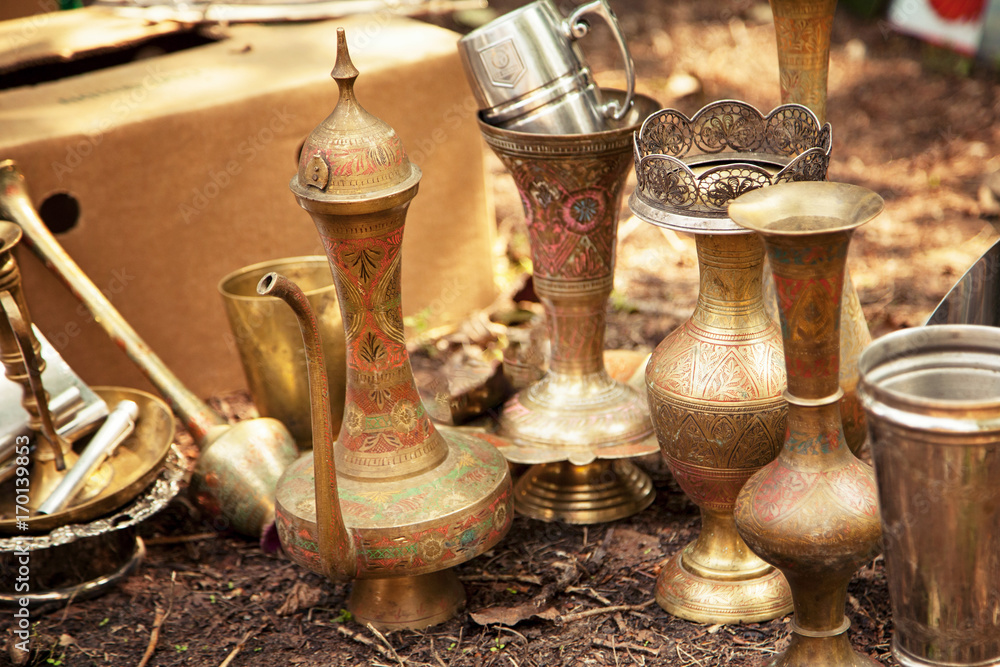 Antique Indian handicraft etched vases and surahi jug at a flea market. Old  brass tableware collectibles at a garage sale Stock Photo | Adobe Stock