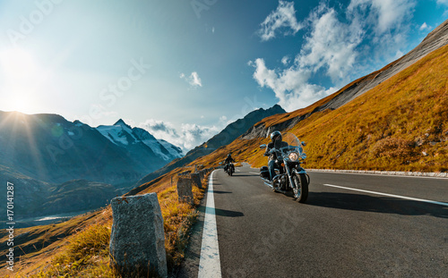 Motorcycle driver riding in Alpine highway on famous Hochalpenstrasse, Austria, Europe.