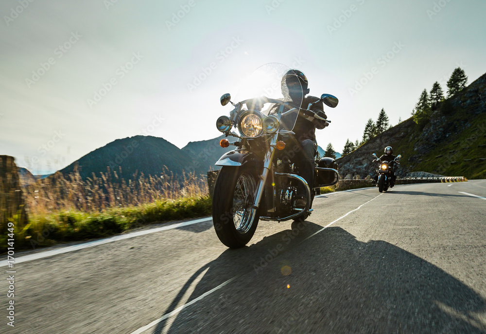 Fototapeta Motorcycle driver riding japanese high power cruiser in Alpine highway on famous Hochalpenstrasse, Austria.