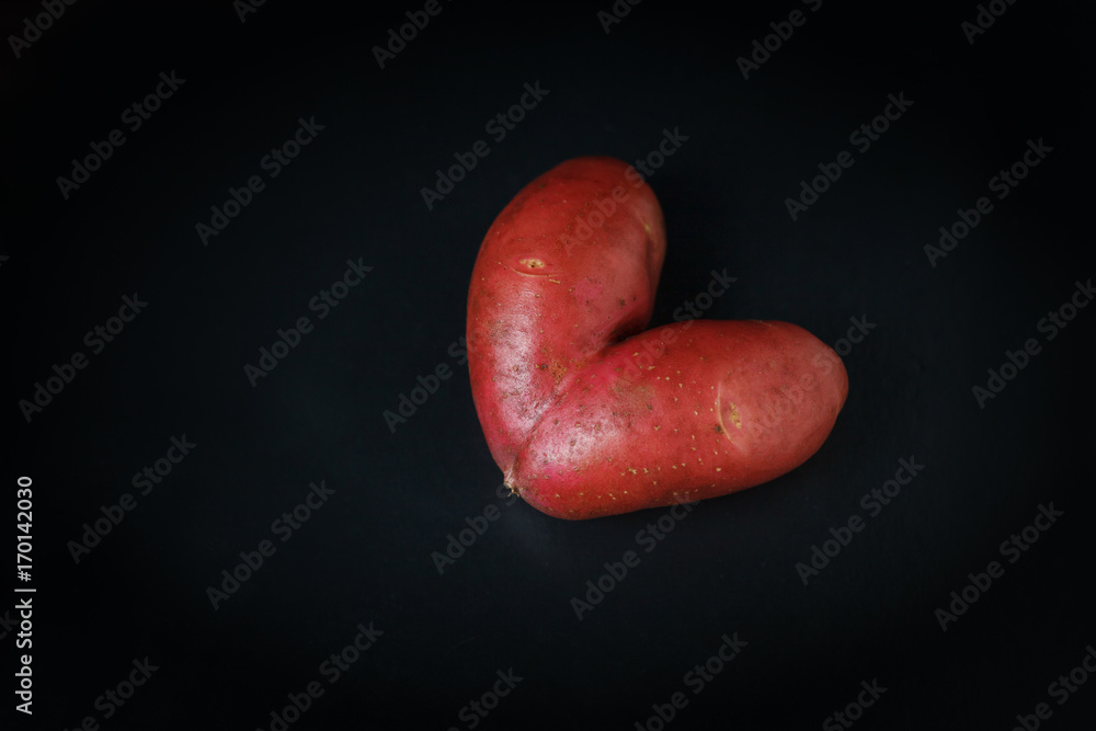 Heart shaped red Potato on a black Heart shaped red Potato on a black