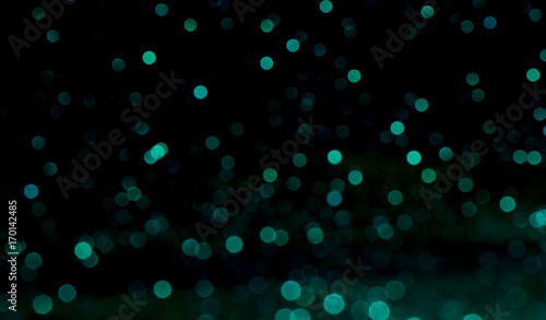 green Sparkling Lights Festive background with texture. Abstract Christmas twinkled bright bokeh defocused and Falling stars. Winter Card or invitation.