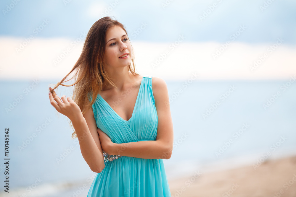 Beautiful young girl in a light blue dress on the beach
Beautiful young girl in a light blue dress on the beach
